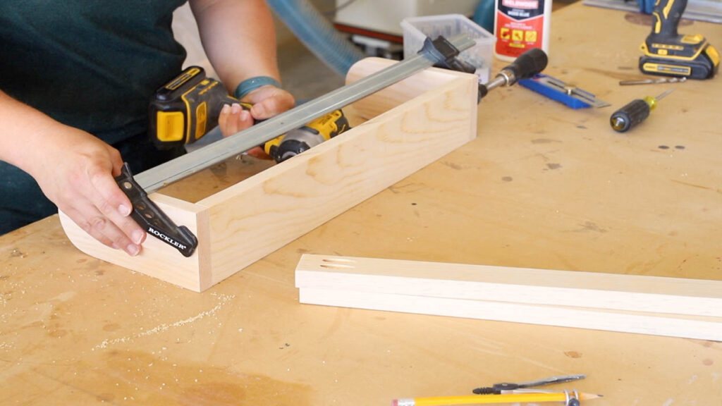 Attaching the leg support to the cornhole board legs with pocket screws and a drill