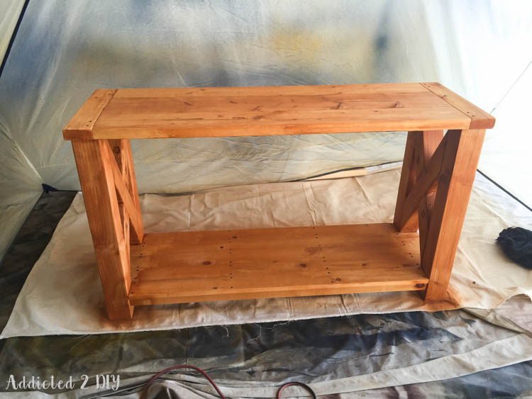 DIY rustic outdoor console table with an uneven bright orange finish after applying Behr weatherproof stain in natural cedar — a staining fail before the fix