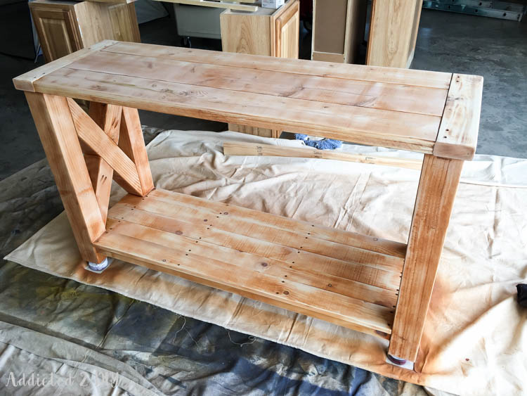 DIY outdoor console table sanded back down after the orange stain disaster, showing lighter wood tones in preparation for gel stain application