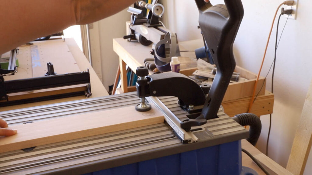 Kreg Foreman pocket hole machine drilling repeated pocket holes into a 1x4 pine board for the cornhole frame