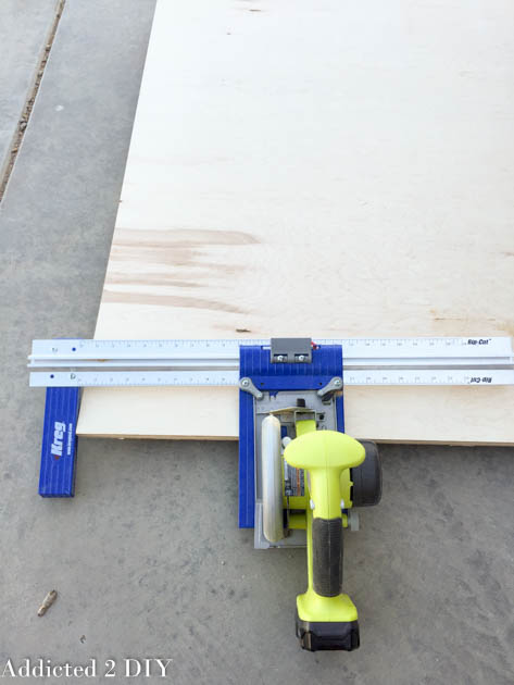 Kreg Rip-Cut guide attached to a Ryobi circular saw cutting a full sheet of plywood on a garage floor