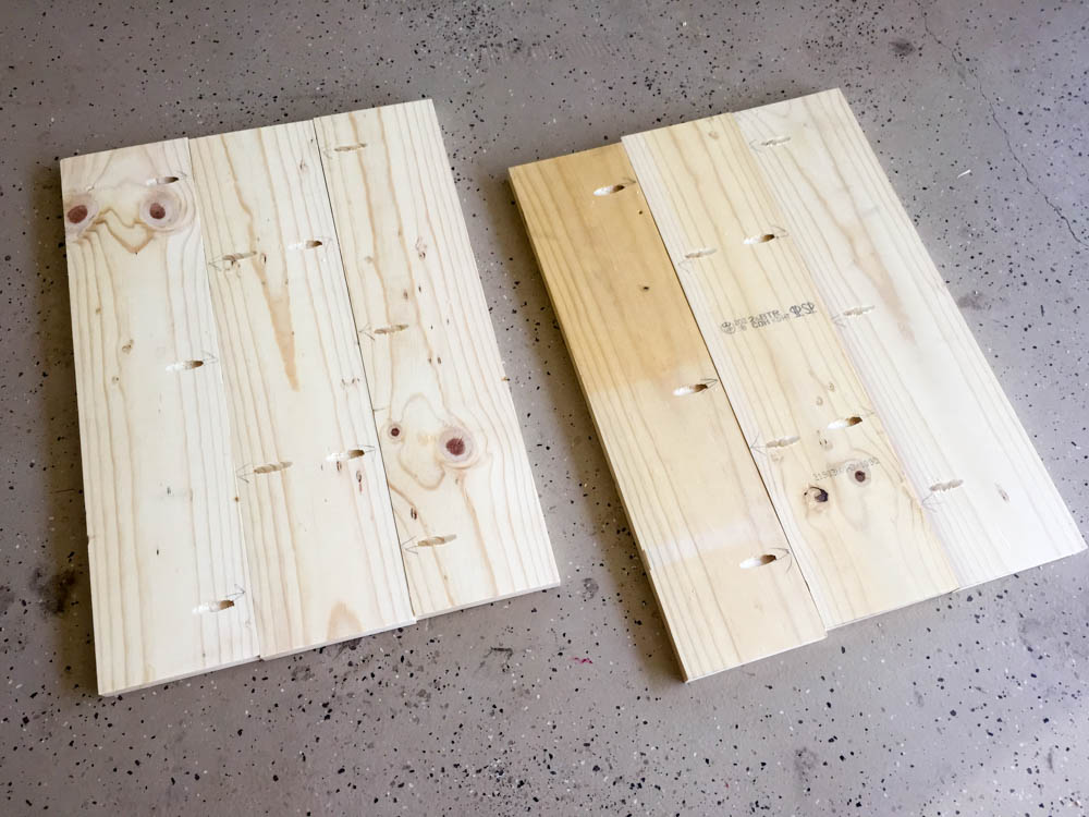Two pine side panels laid face-down showing pre-drilled Kreg pocket holes for nightstand assembly