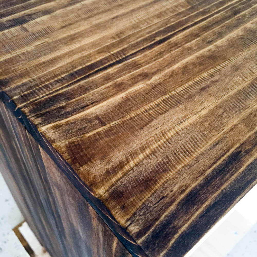 Close-up of nightstand top and corner stained with Minwax Provincial showing how stain deepens the grinder saw-mark texture for a rustic look