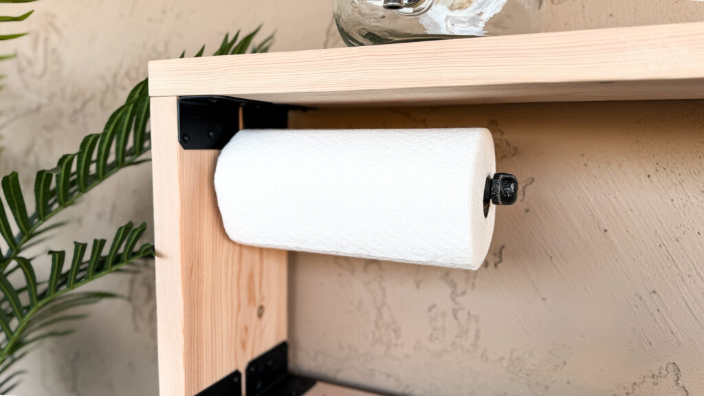 Under-shelf paper towel holder made from threaded iron pipe on the finished outdoor console table
