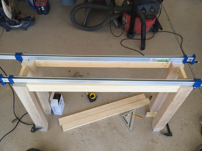 Table frame legs and rails clamped together on sawhorses using parallel clamps during assembly