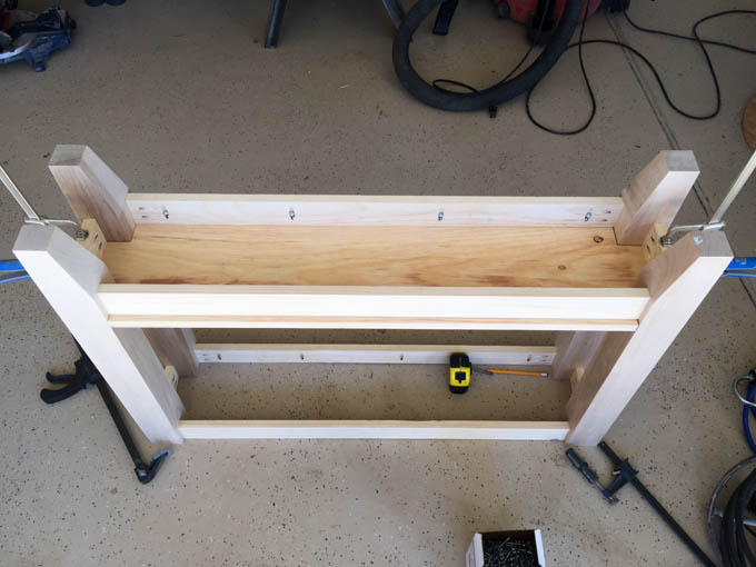 Top-down view of the assembled console table frame with pocket screw holes visible, clamped and ready for the tabletop