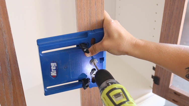 Using a cabinet hardware jig to position and drill for door knobs