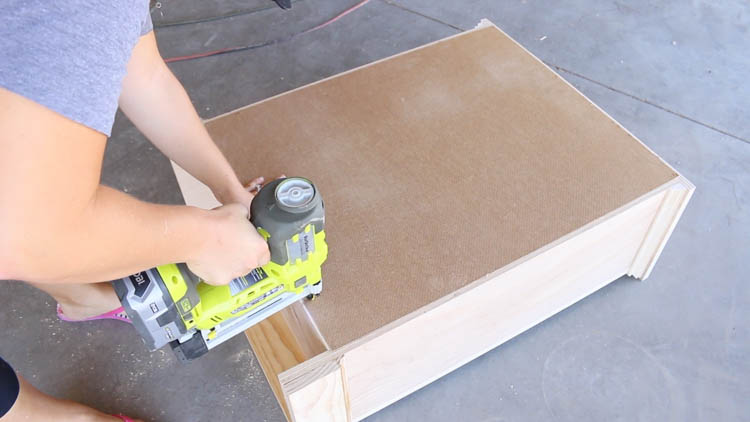 Stapling hardboard backing onto the back of the cabinet