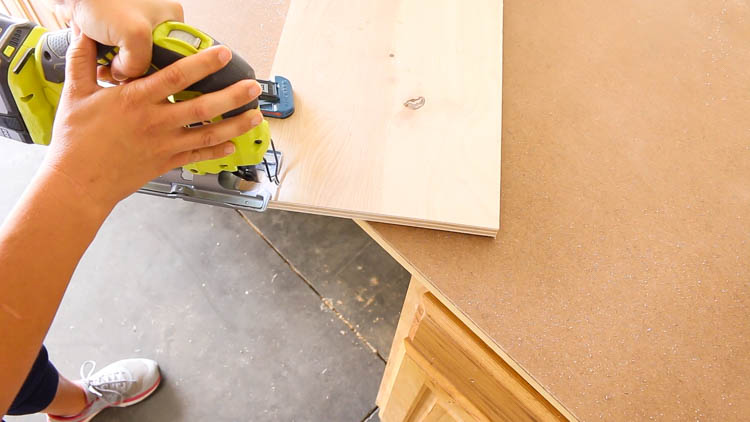 Cutting a notch into the plywood cabinet bottom with a jigsaw