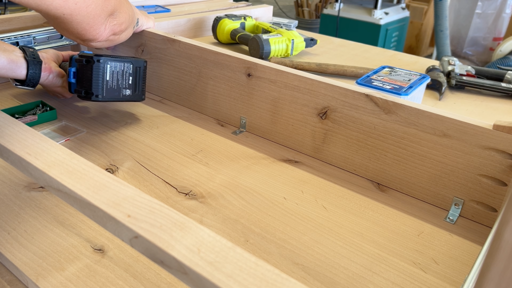 attaching table top to the table base with angle brackets and screws