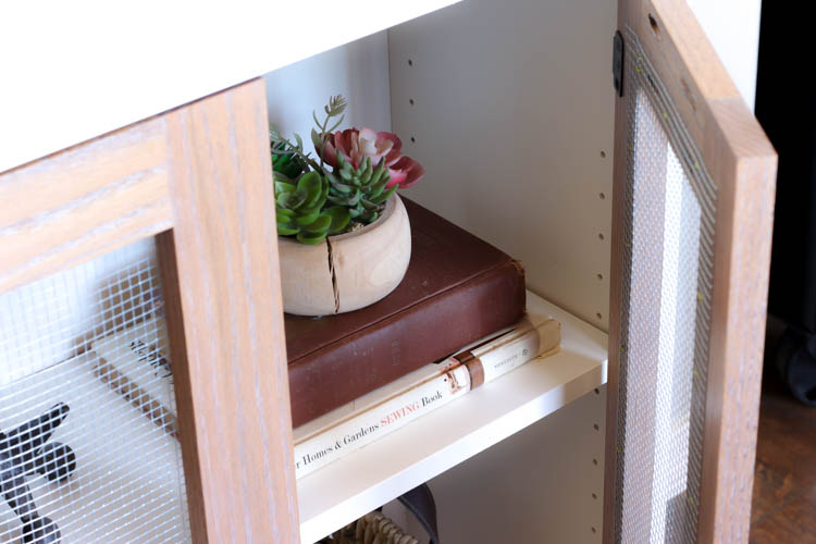 close up of two tone cabinet with door open highlighting the adjustable shelf