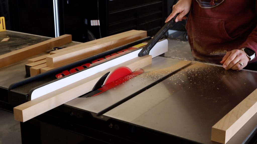 Ripping a board down to a 2x2 on a table saw for the base of a DIY side table with storage