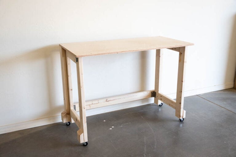 an angled view of the mobile folding workbench against a wall in a wood shop
