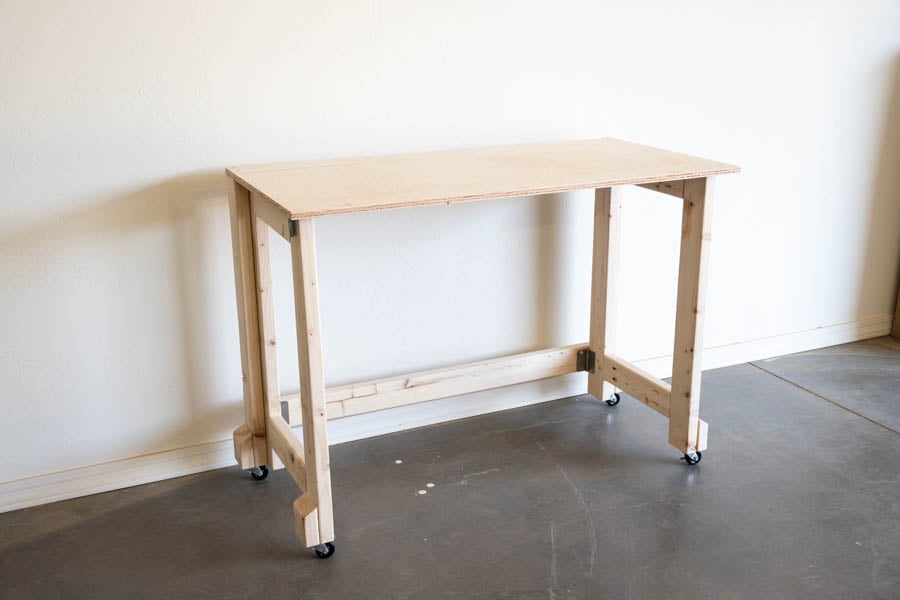 an angled view of the mobile folding workbench against a wall in a wood shop